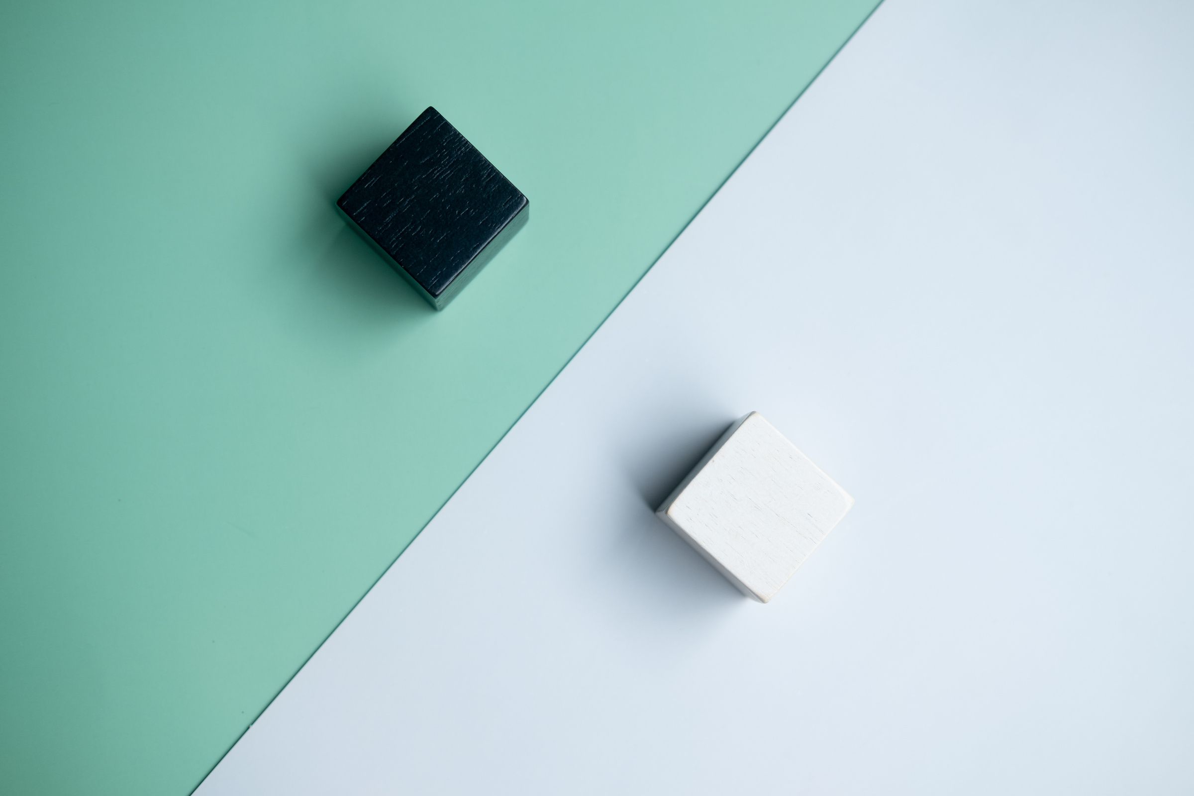 Wooden cube white placed opposite side wooden cube black. The concept of opposite