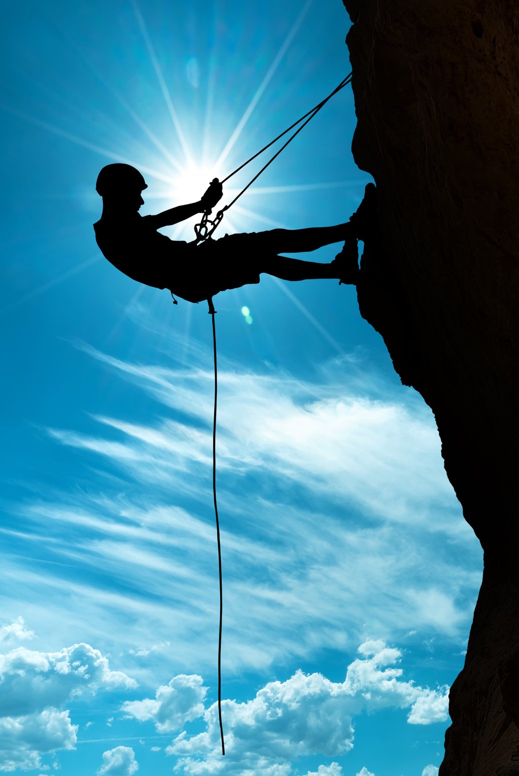 Climber silhouette over shining sun